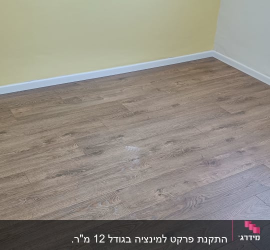 רצפת פרקט עץ בחדר עם קירות צהובים ולבנים